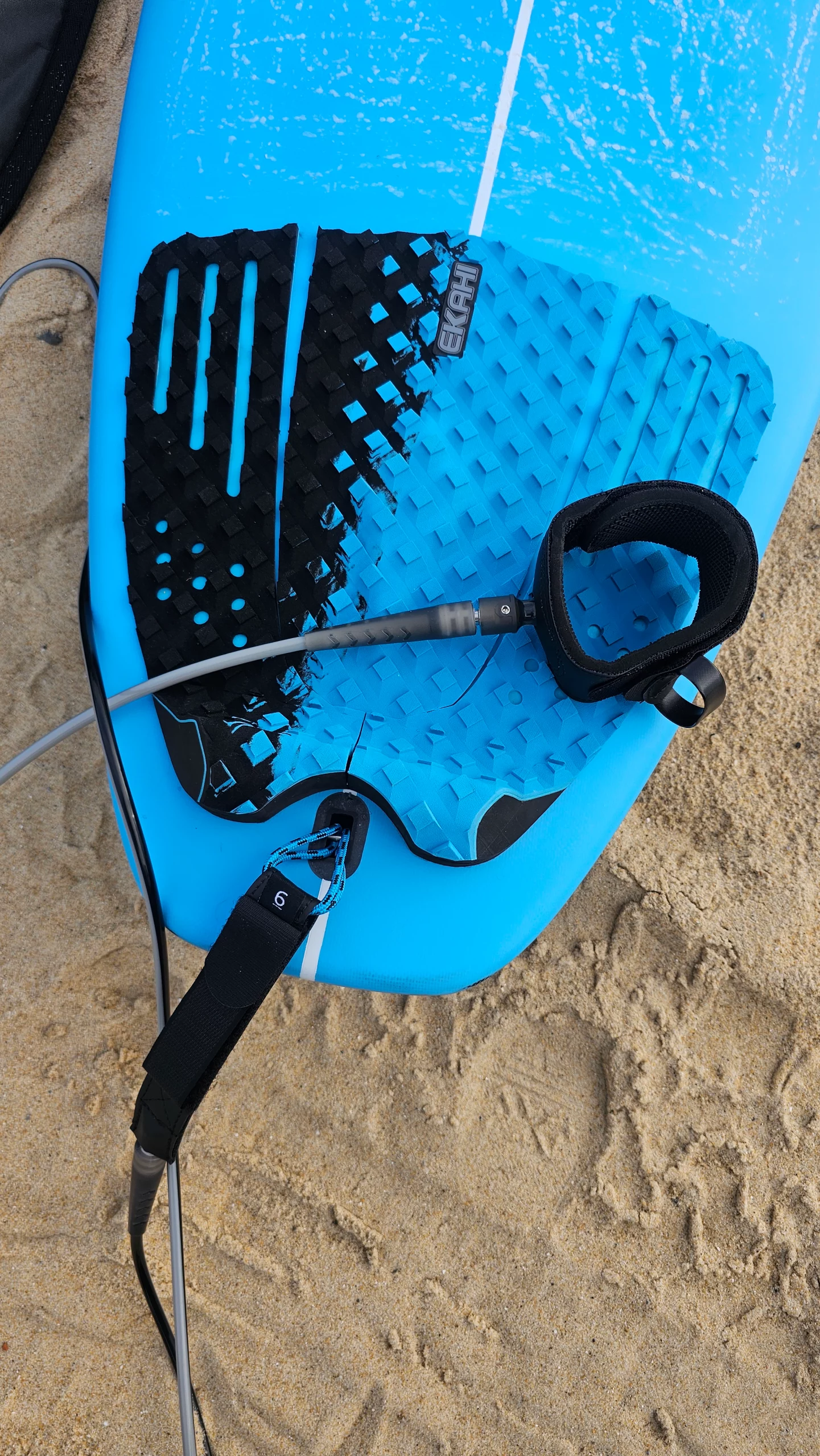 Top view of the EKAHI Round black/blue grip with the black/grey Leash on a Blue Squash carbon surfboard