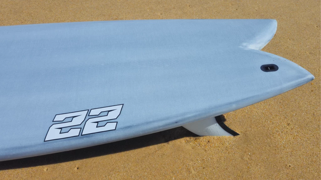 Top view of the fish tail with the twin fins of the Ekahi pearl white 22 carbon surfboard