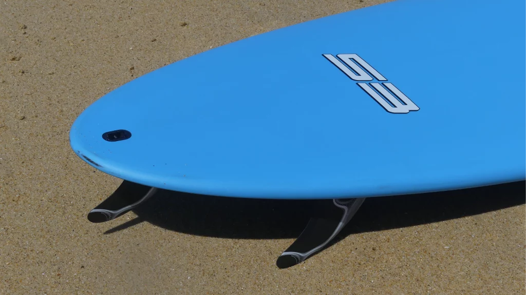 Close-up of the tail on an Ekahi 53 carbon surfboard, blue deck