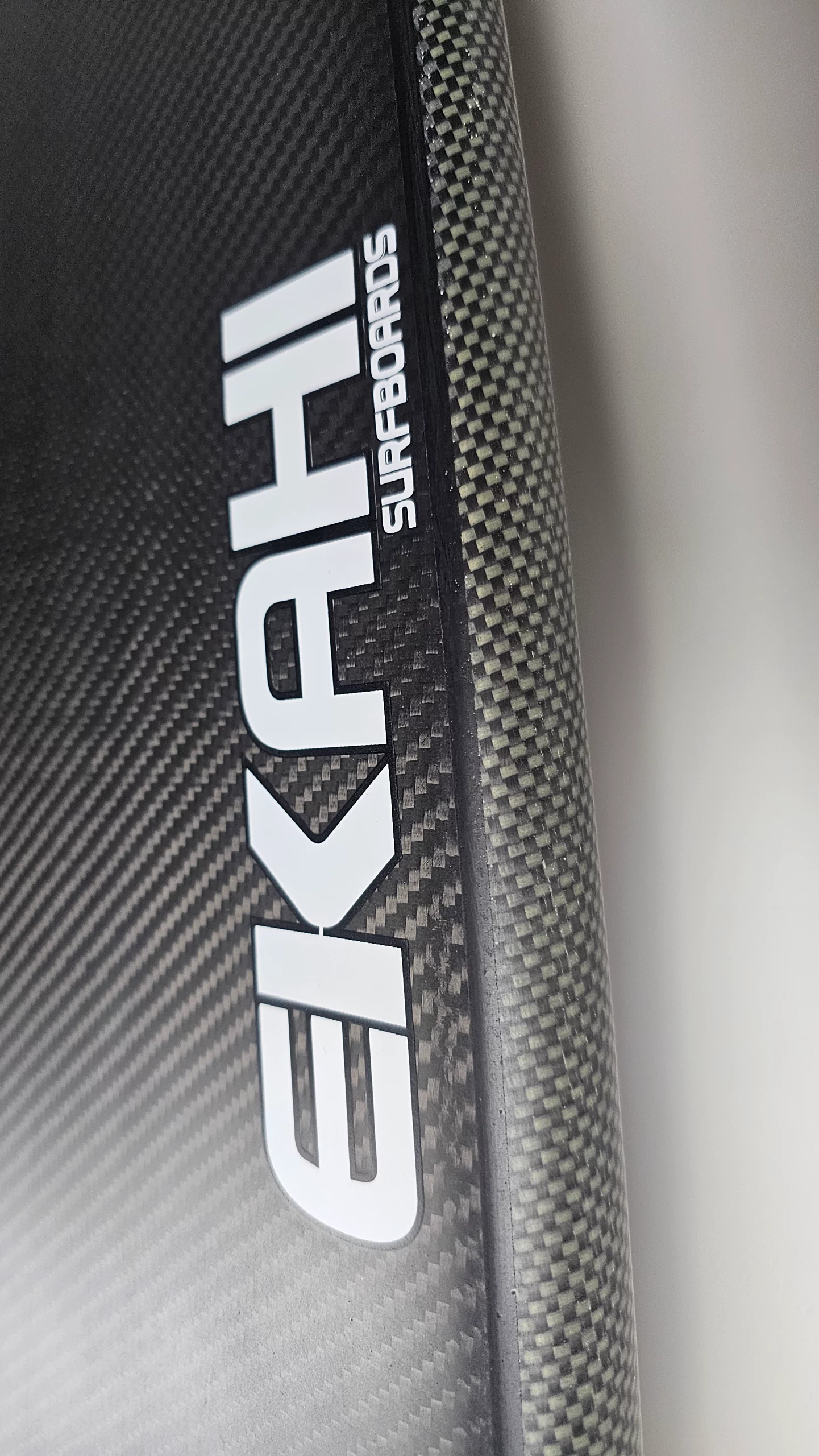 Bottom view of the EKAHI logo on a a ekahi carbon kevlar Channels carbon surfboard 5'8.