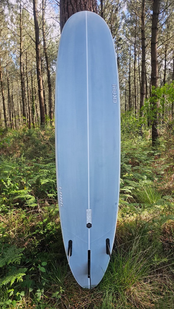Ekahi Long surfboard standing against a tree in a forest, bottom view