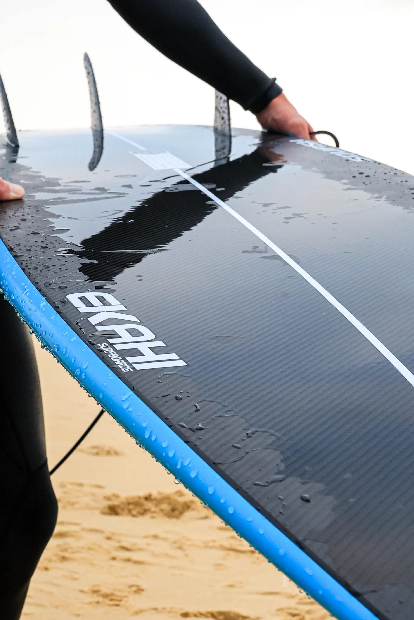 Surfer showing the bottom of the blue 5'8 Squash in carbon technology