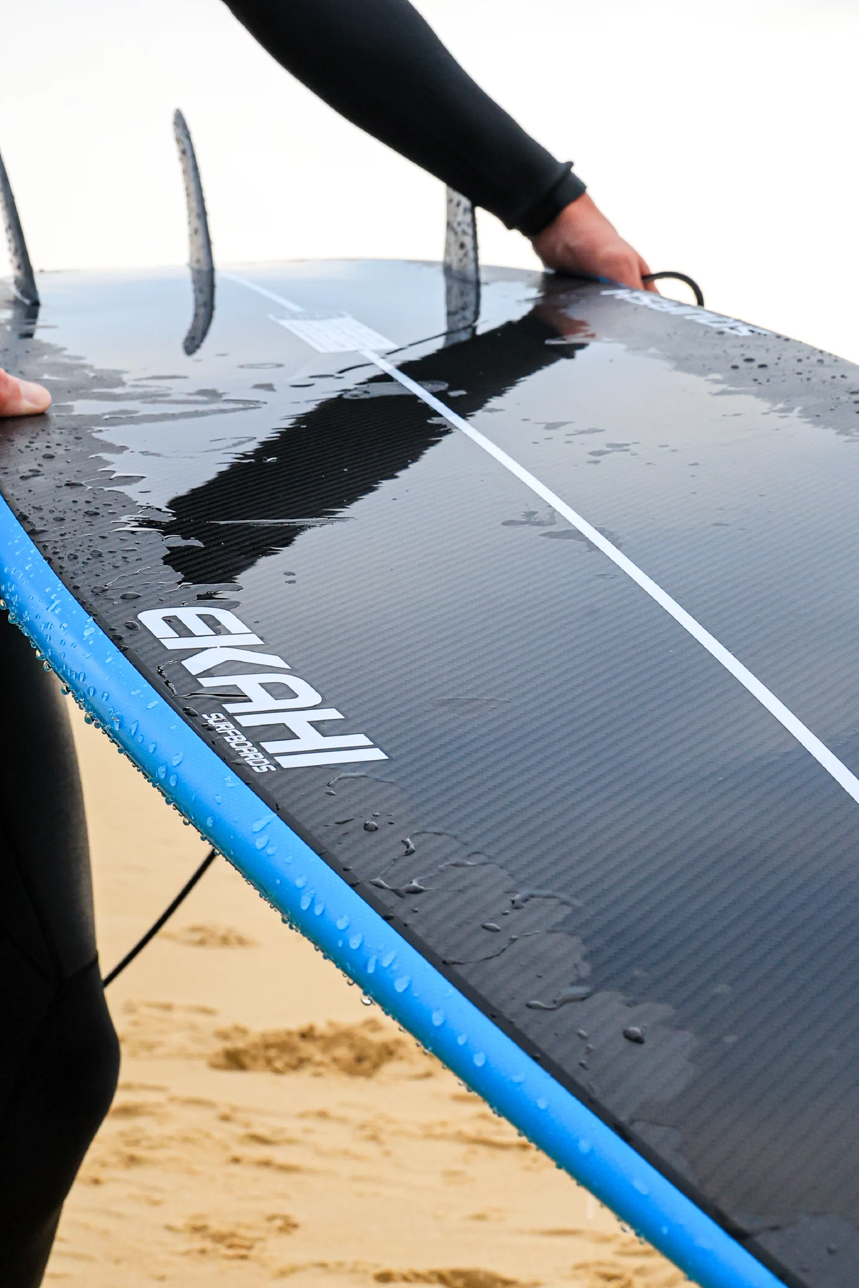 Surfer showing the bottom of the blue 5'8 Squash in carbon technology