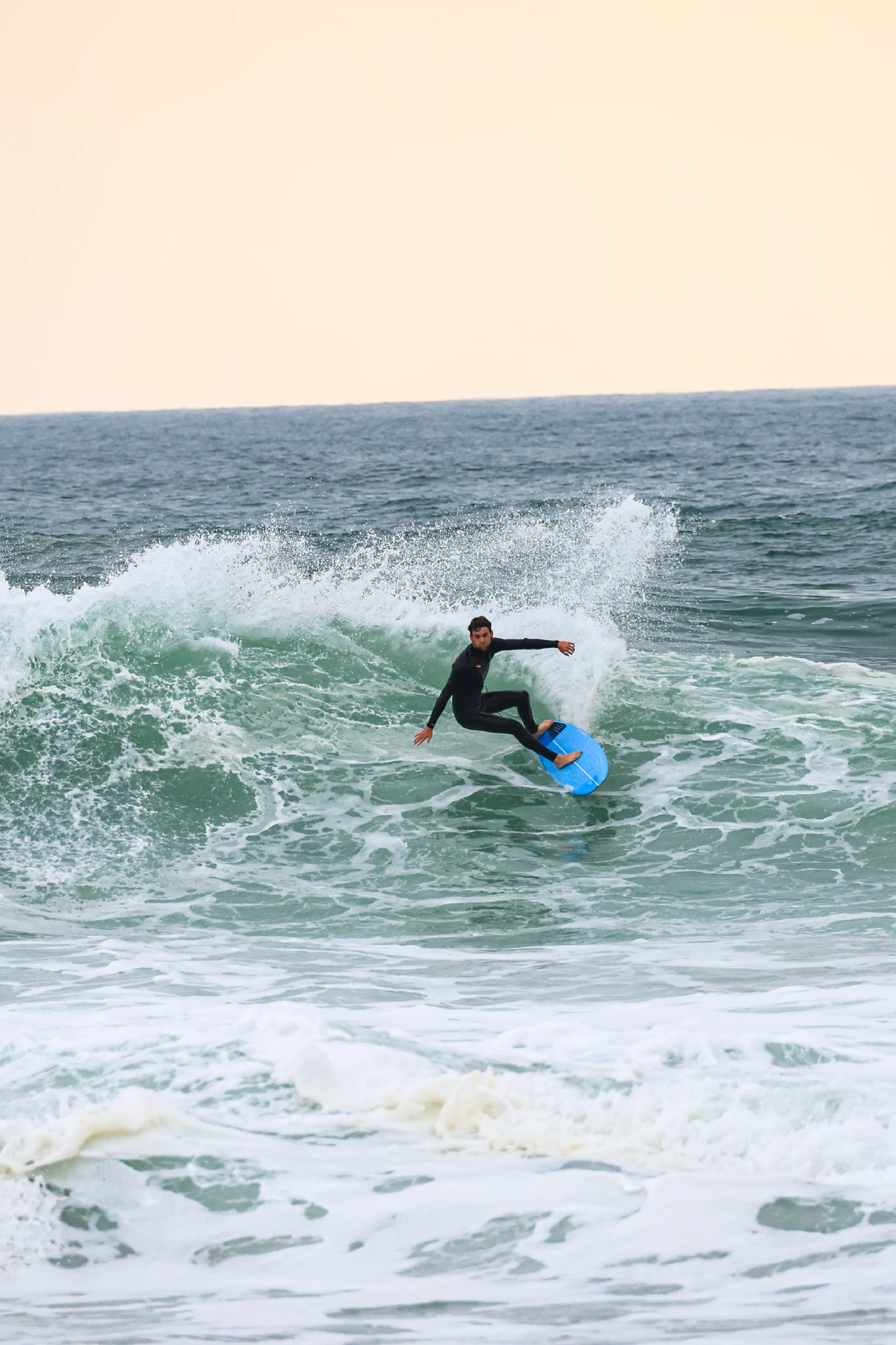 Surfer carving with the blue 5'8 Squash in carbon technology