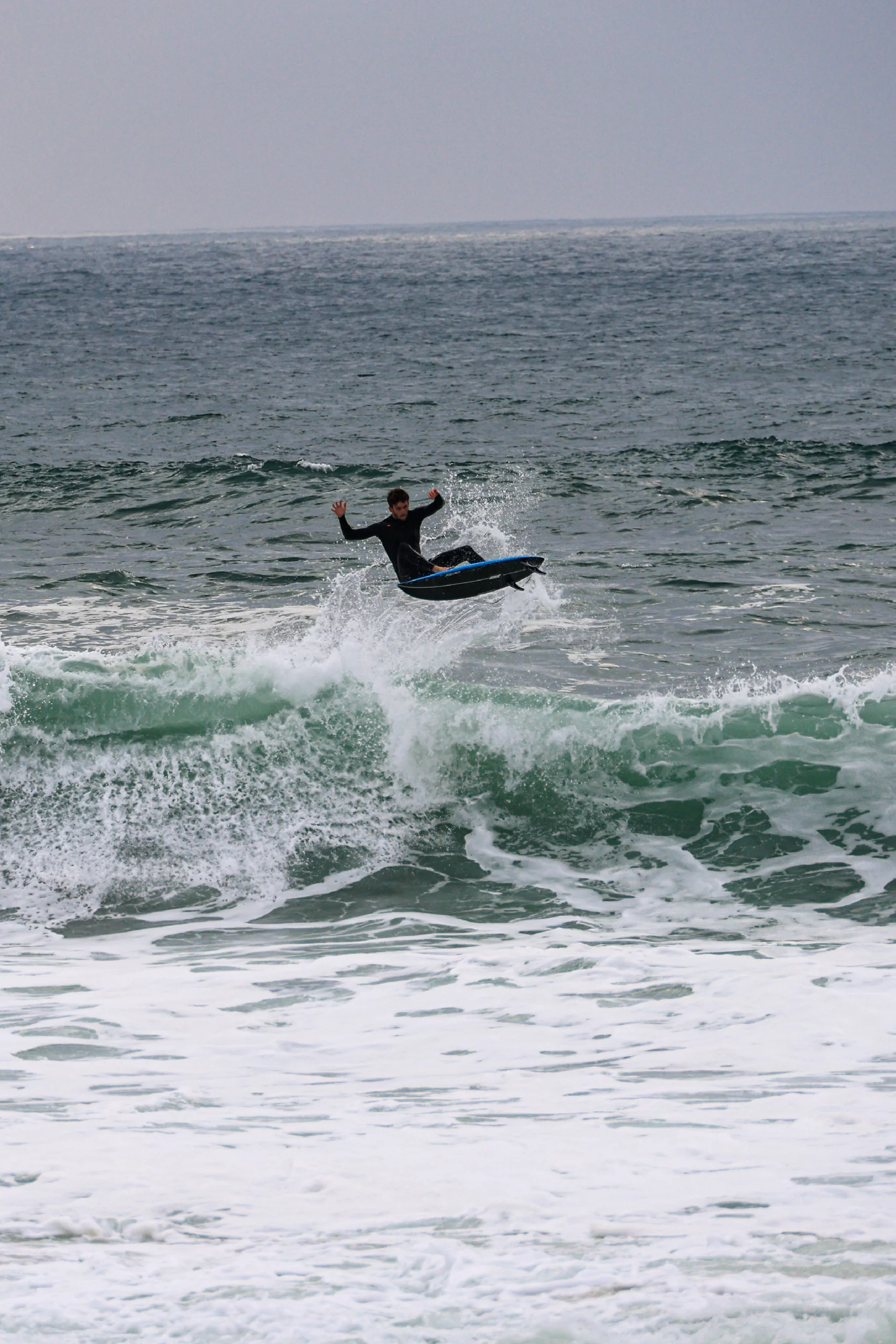 Surfer making an air with the blue 5'8 Squash in carbon technology
