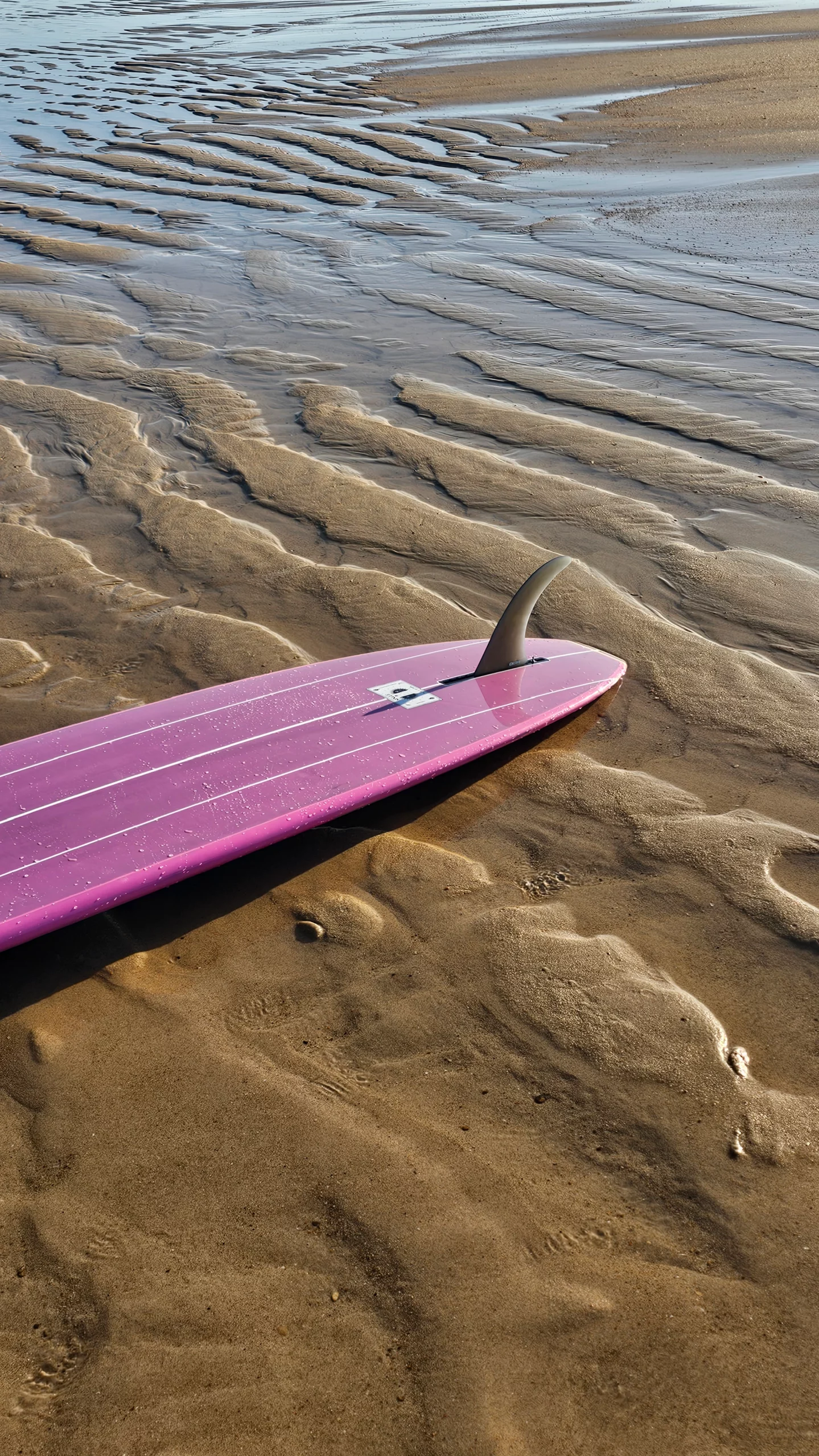 View of the single fin on the EKAHI pink classic longboard on the sand.