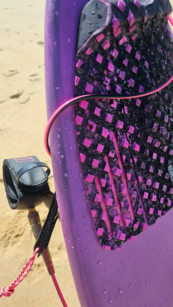 Ekahi Squash Pad carbon surfboard, pink deck, lifestyle photo on the beach