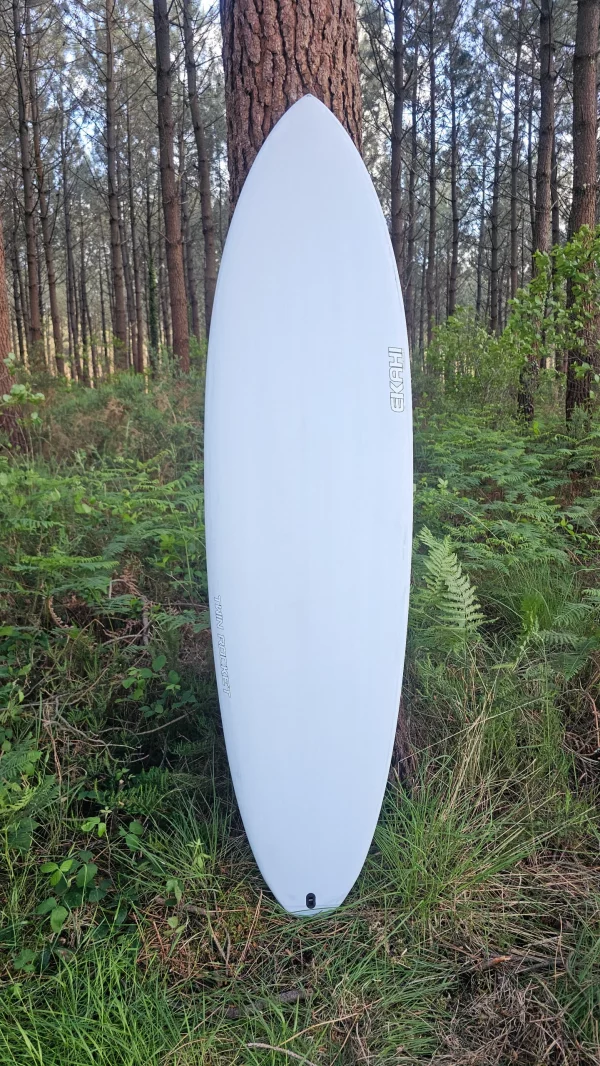 Top view of Ekahi white Twin rocket carbon performance surfboard in the forest.