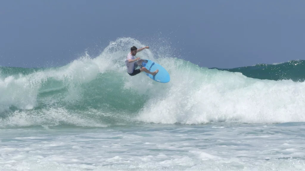 Surfer making a re-entry with a blue carbon Channels surfboards 5'8.